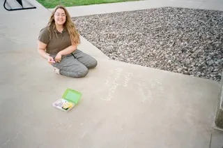 Gwen playing with chalk on a university sidewalk.